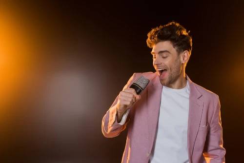 man-singing-while-holding-microphone-on-black-2024-11-11-09-43-31-utc