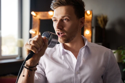 young-man-with-microphone-is-singing-at-home-2024-10-18-07-50-41-utc